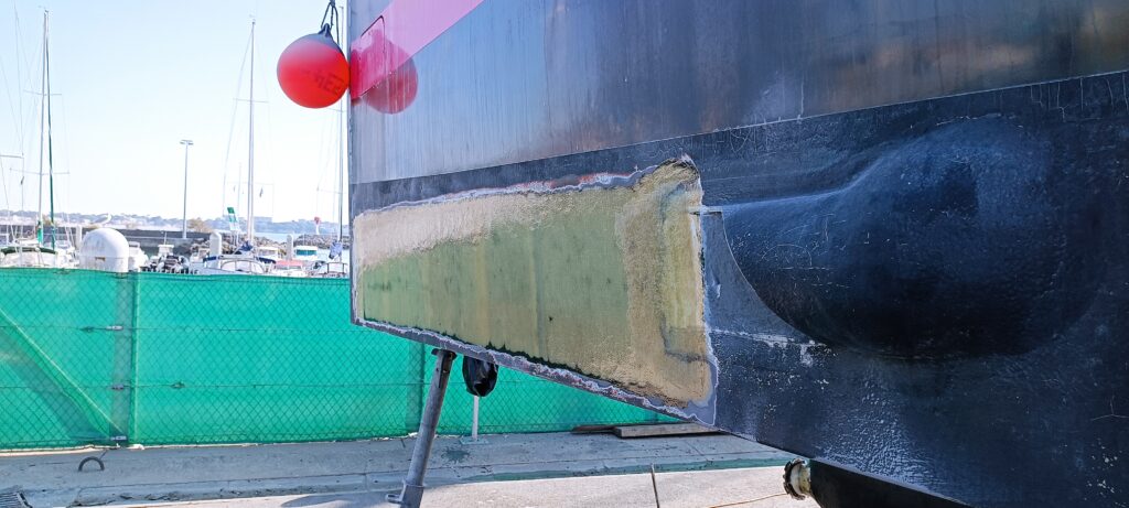 Black hull with damaged laminate, before surface repair – composite repair by Plasti Pêche