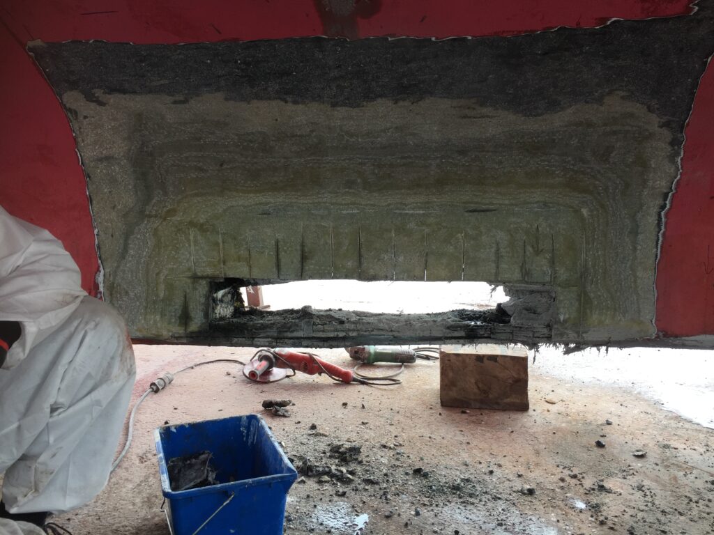 Keel opened under a red hull, before structural repair – composite repair by Plasti Pêche